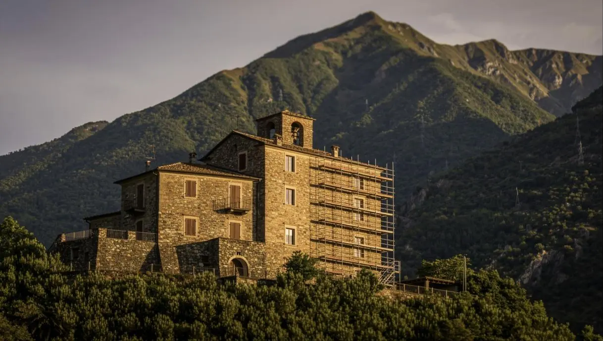 Borgo di montagna italiano con edificio in pietra e ponteggi per lavori di consolidamento sismico